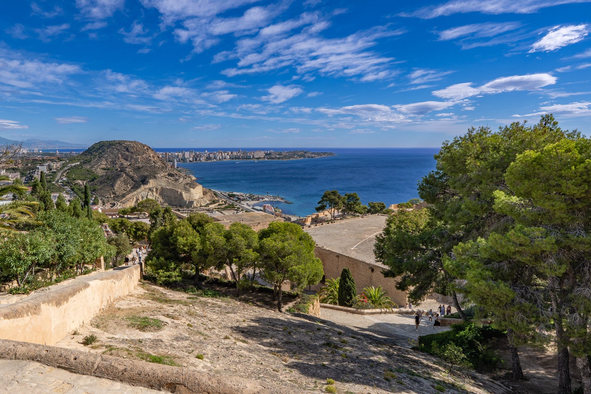 Ocean and cityscape view from Alicante, Spain under a bright blue sky.