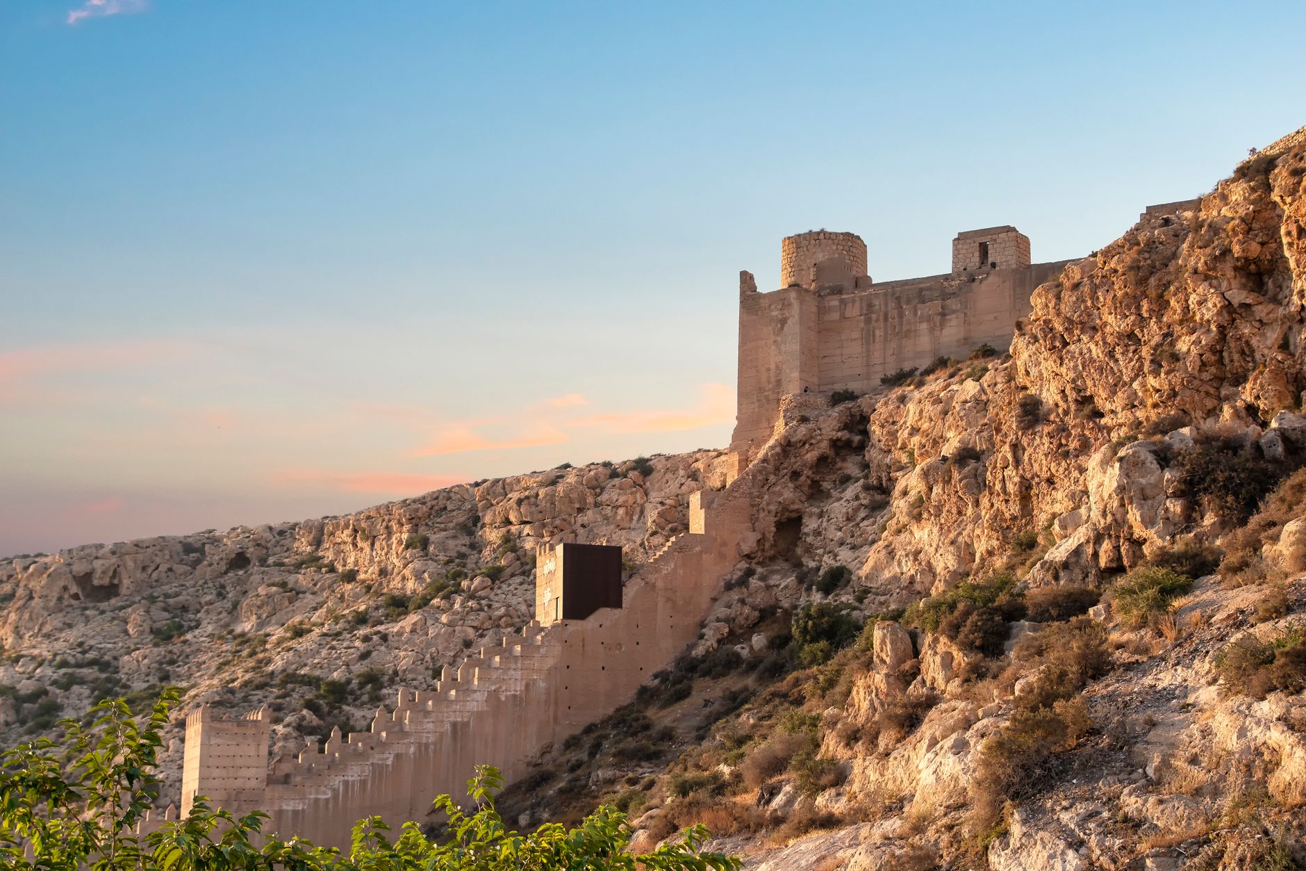 View of Alcazaba fortress on a cliff during sunset in Almería, Spain.