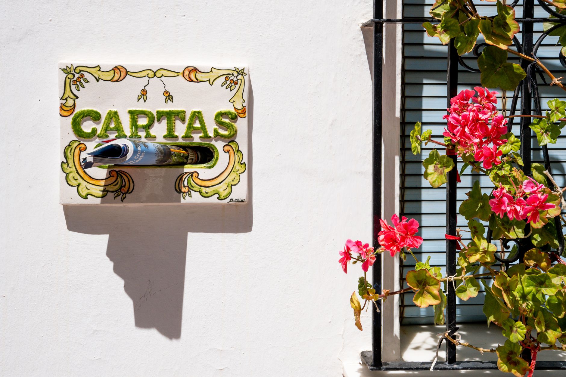 White wall with flowers and decorative Spanish mailbox in Benalmádena, Andalucía.