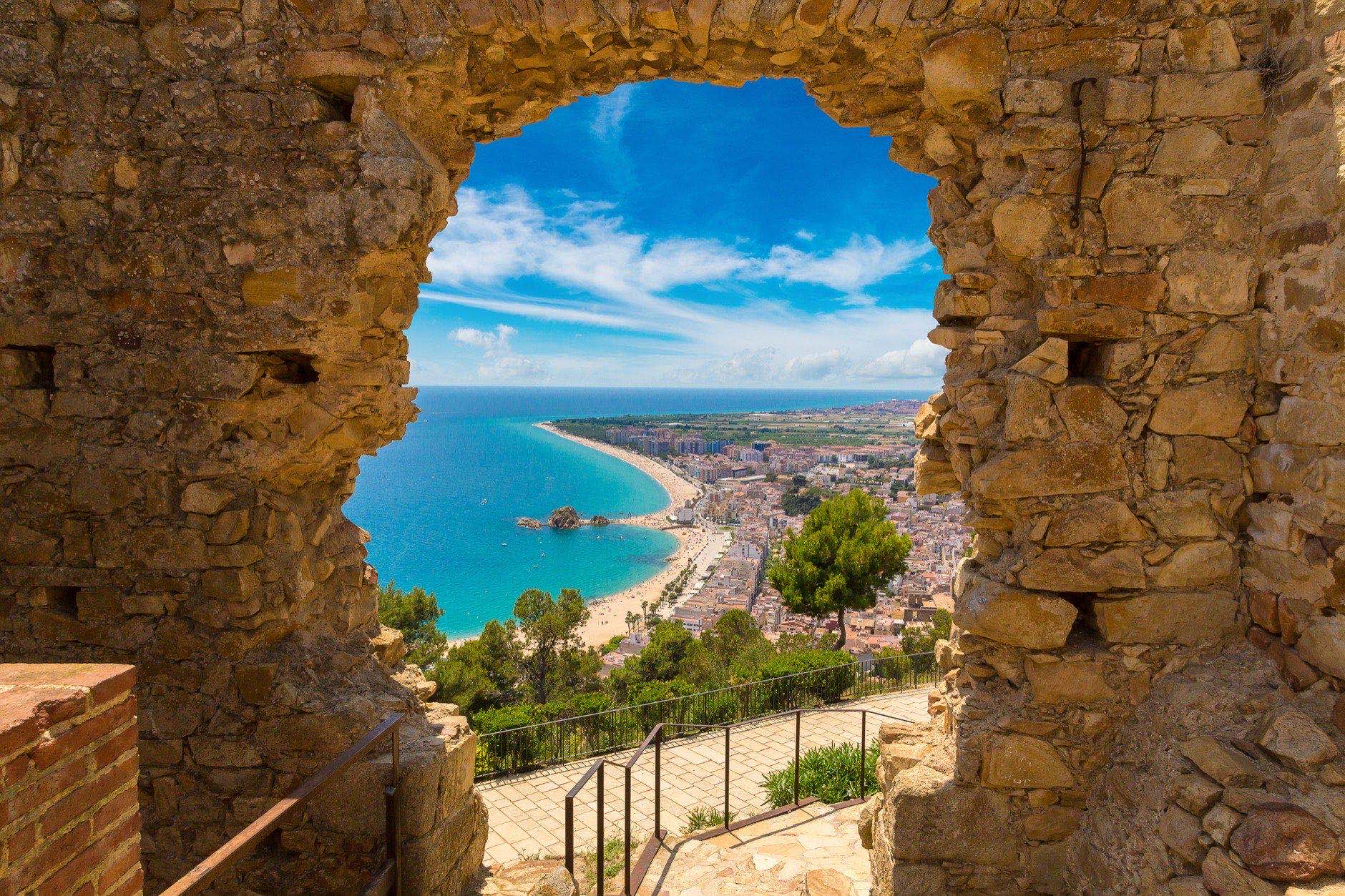 Blanes beach through a stone door of St. John Castle. Aerial panoramic view in Costa Brava in a summer day, Spain