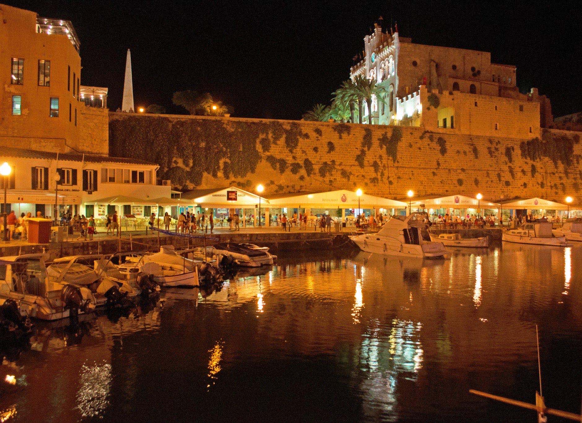 Menorca, Balearic Islands, Spain, July 7, 2013: night skyline of the old port and the city walls of Ciutadella, Ciutadella de Menorca, former capital city of Menorca, in the western end of the island