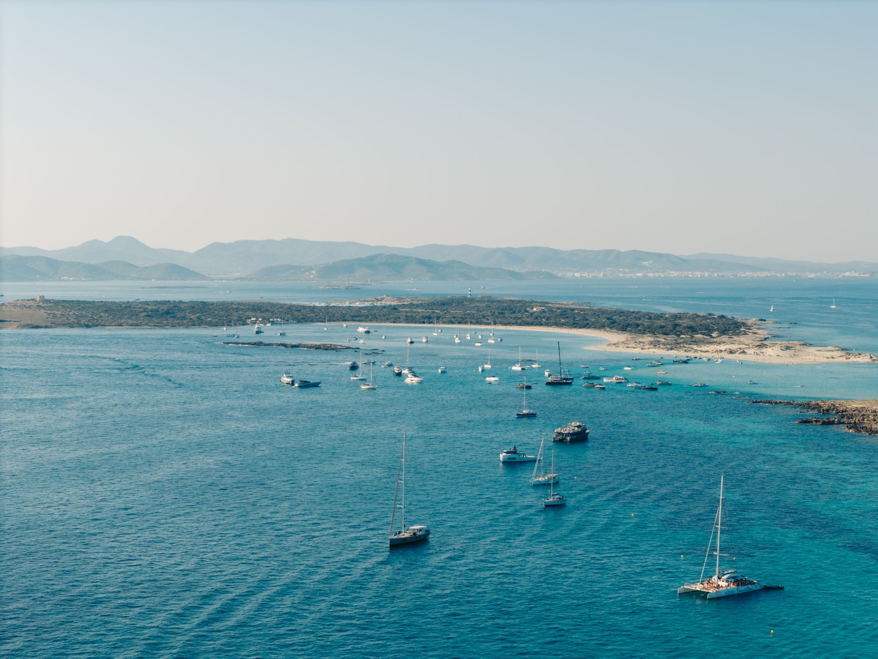 Discover a summer scene with sailboats near Formentera, Balearic Islands.