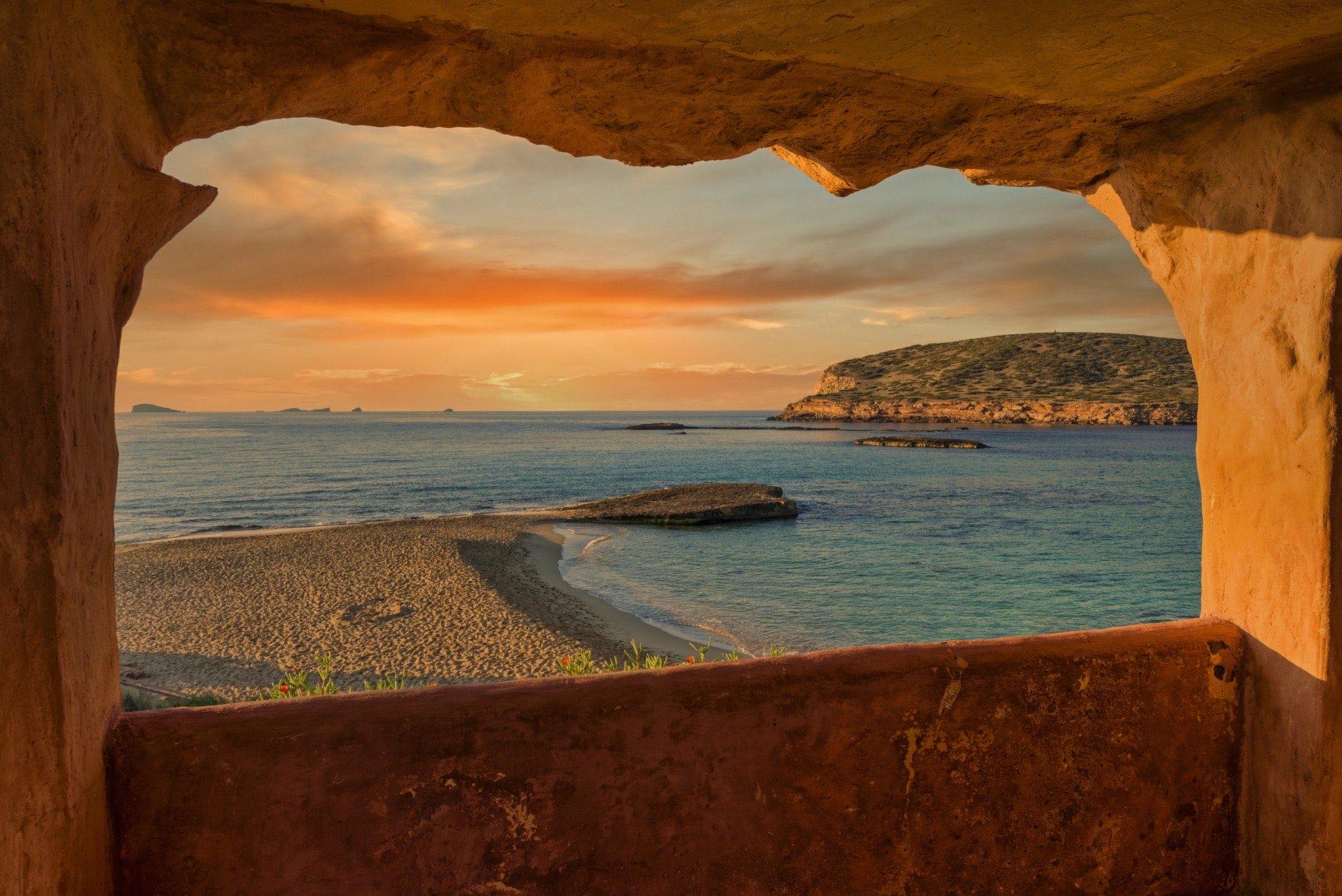 Window to Cala Comte de Ibiza at sunset, Spain