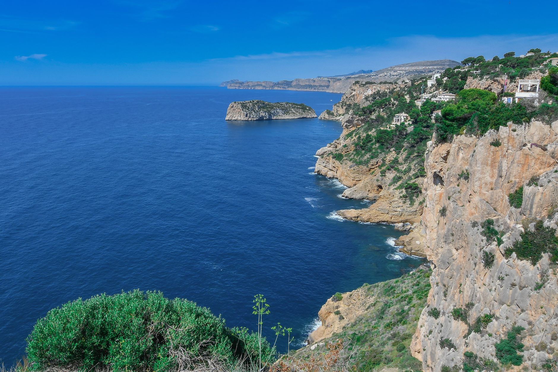 A view of the rugged coastal cliffs and blue sea in Jávea, Spain.