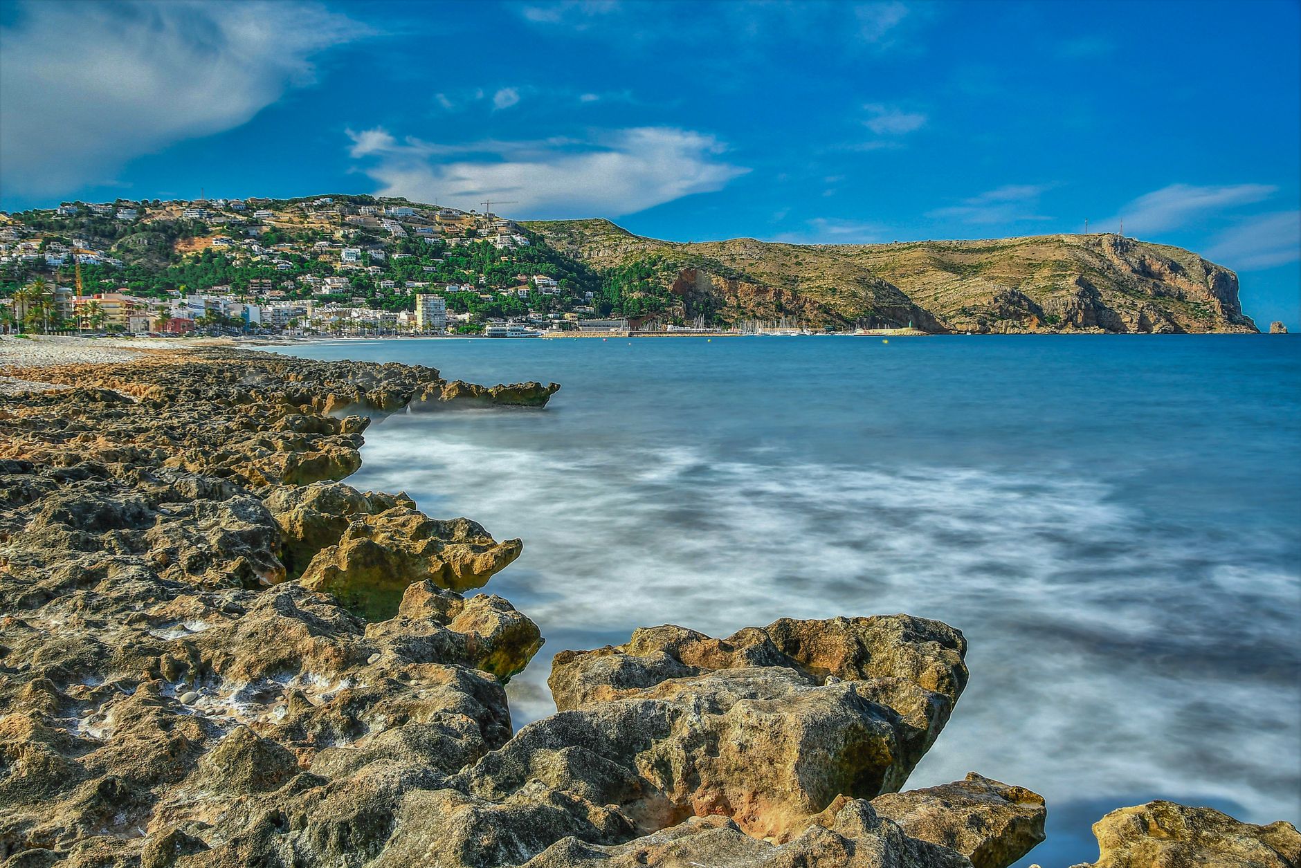 Coastal landscape of Jávea, Spain with rocky shoreline and blue waters.