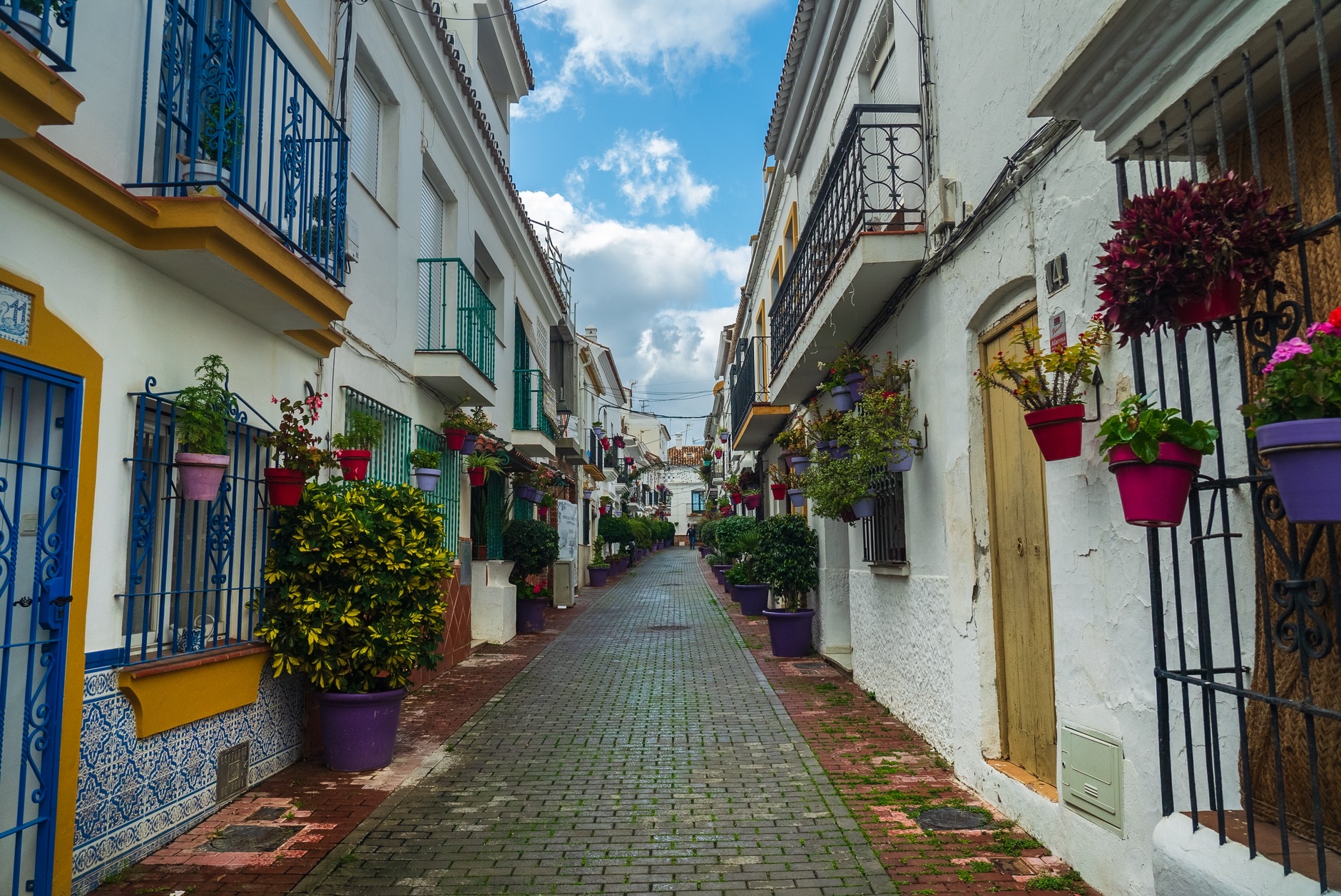Alley in Marbella, Spain featuring flowers and traditional architecture.