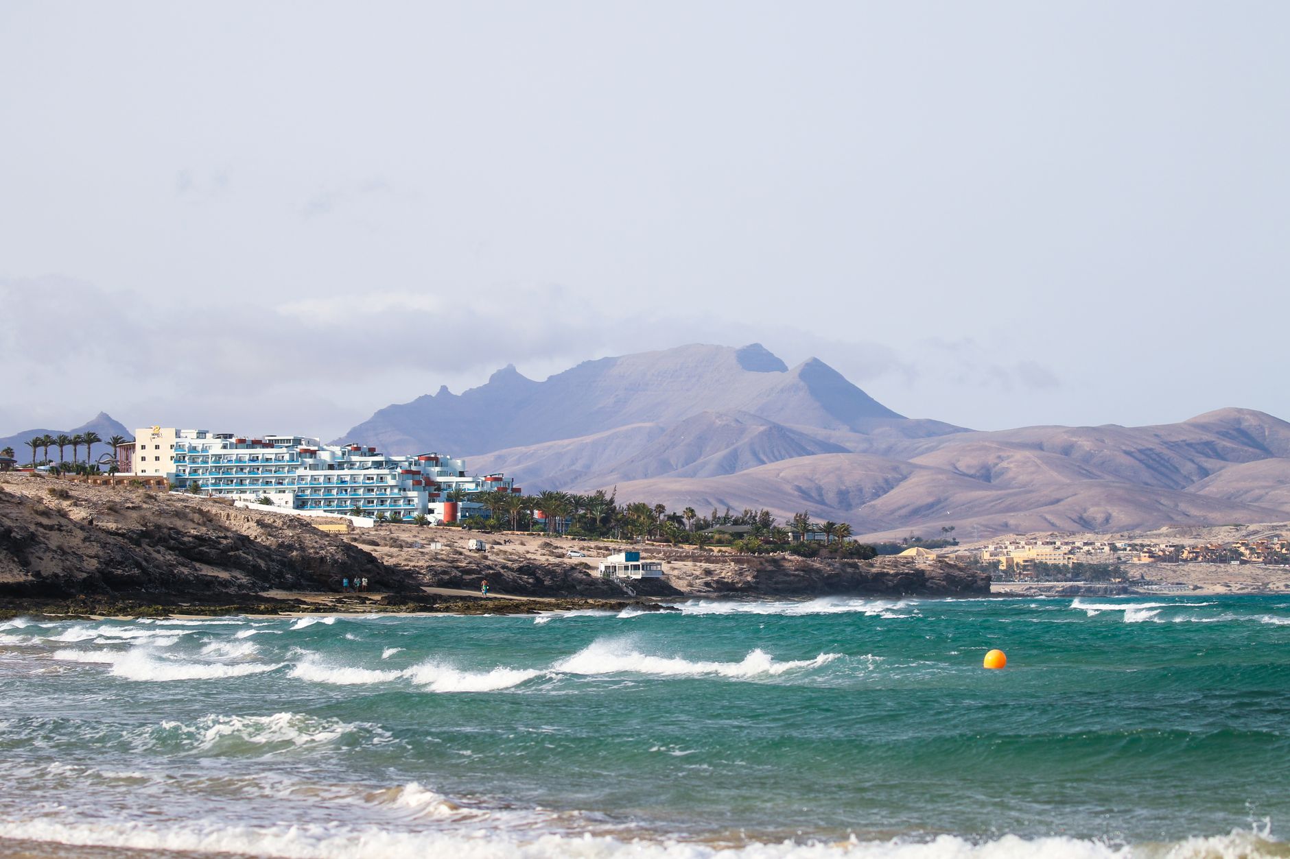 Morro Jable in the municipality of Pájara, Fuerteventura, Spain — view of Fuerteventura coastline with waves and mountains in the