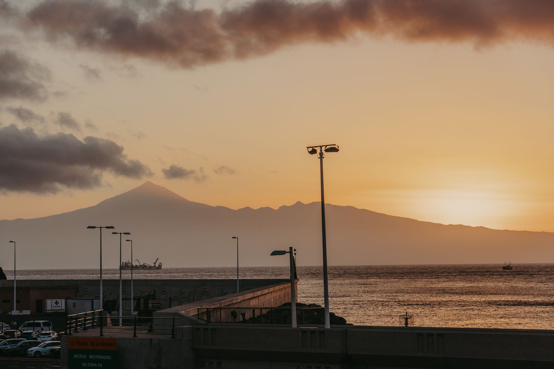 Sunset over Tenerife viewed from San Sebastián de La Gomera, capturing coastal and mountain landscapes.