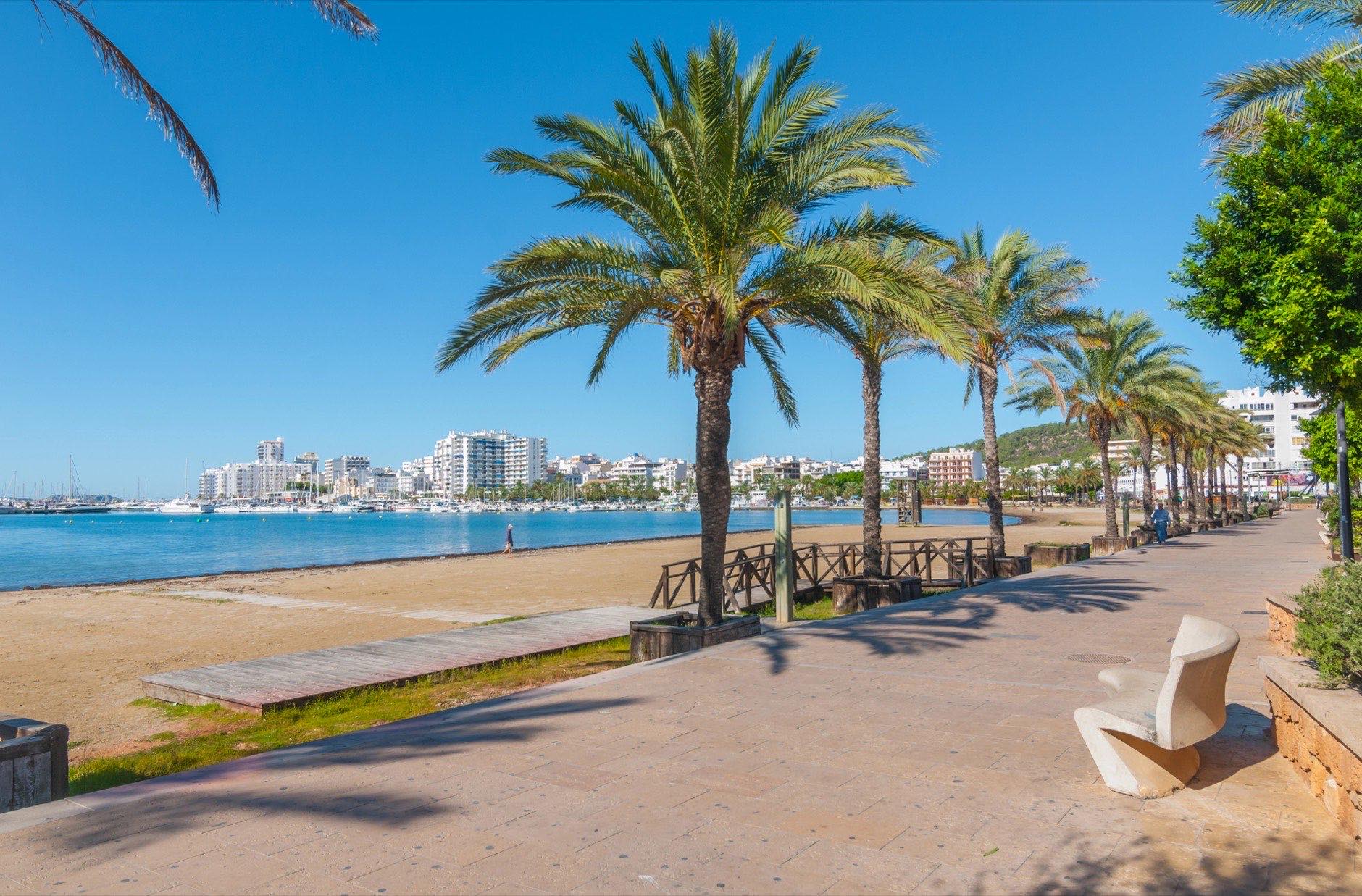 Ibiza sunshine beach in Sant Antoni de Portmany, Take a walk along main boardwalk or in the sand. November beach in warm morning sunshine.