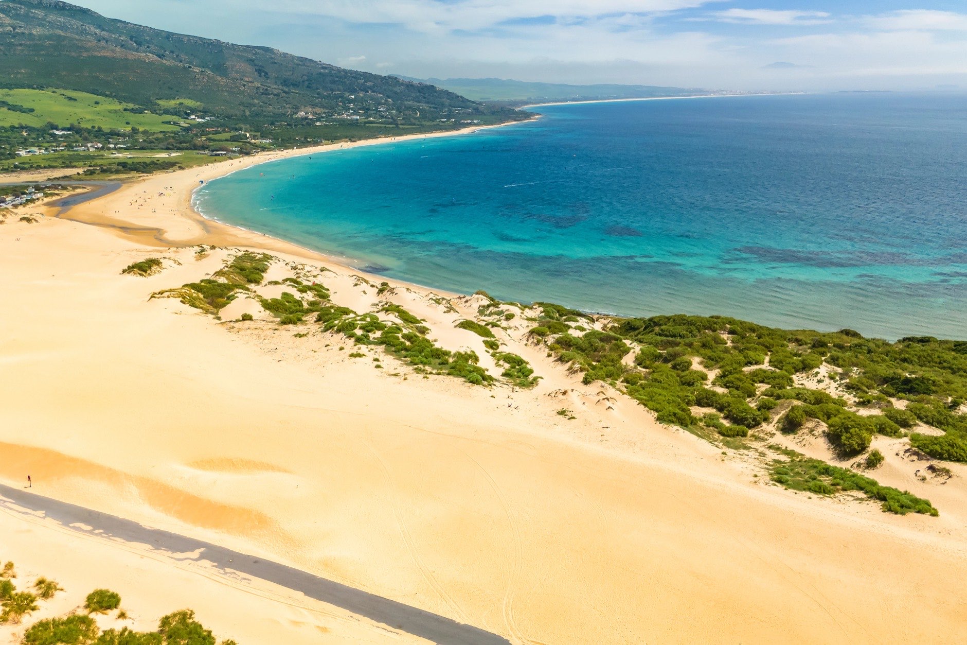 Aerial view of the Dune of Valdevaqueros in Spain. Asphalt road between the sand dunes in Tarifa. The Valdevaqueros dune, famous with strong easterly winds blowing in the Strait of Gibraltar.