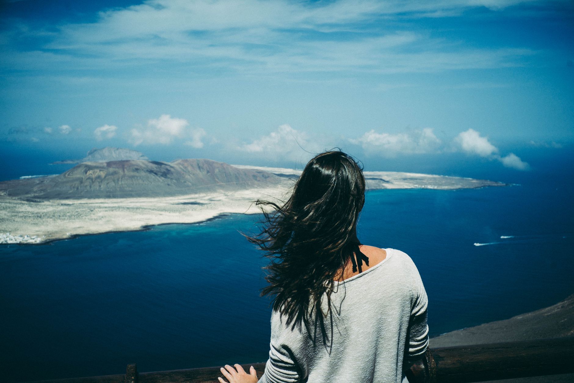 Woman gazing at the ocean and mountains from a viewpoint in Teguise, Spain.