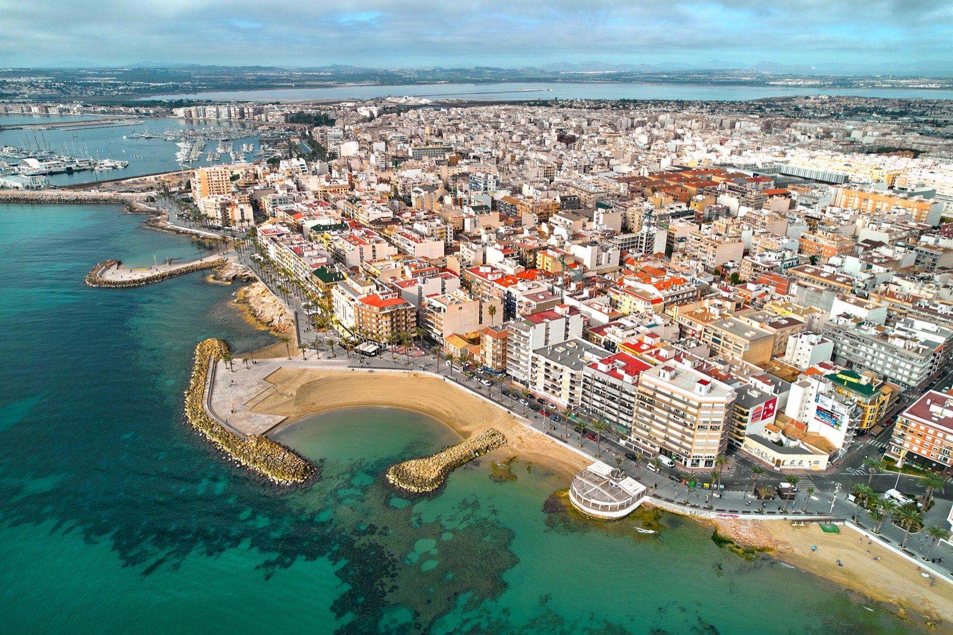 Drone point of view sandy beach, coastline of Playa del Cura in spanish resort Torrevieja city at summertime. Costa Blanca. Spain. Travel and tourism concept