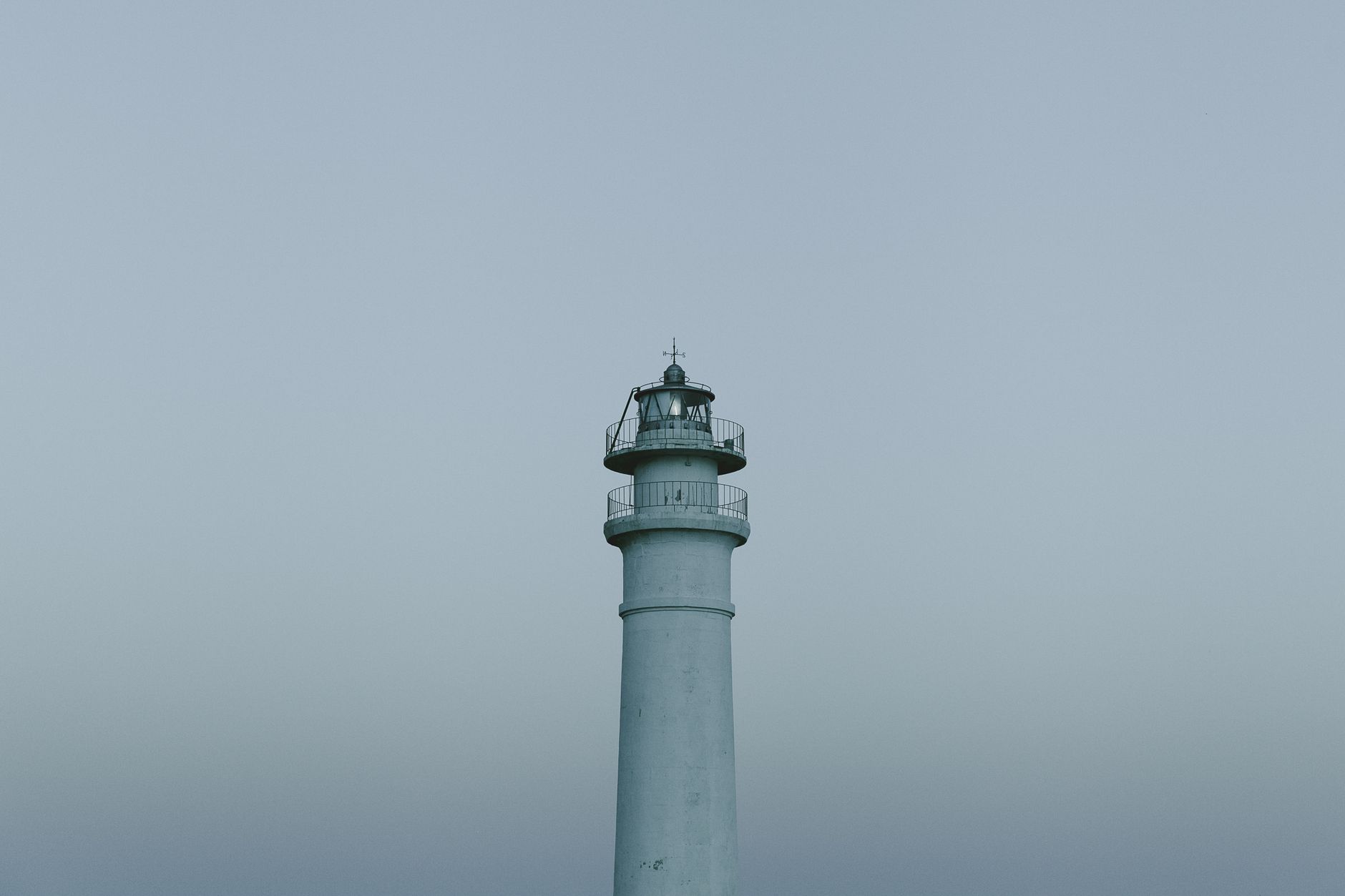 A view of a lighthouse standing tall against a foggy sky in Torrox Costa, Spain.